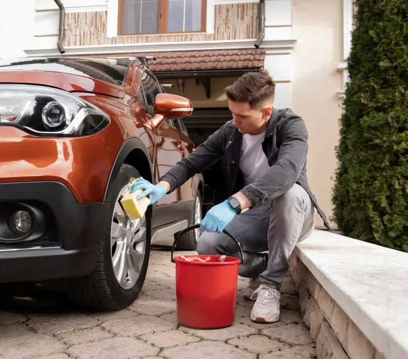 Lavage auto à domicile Ayrens : professionnel intervenant sur un véhicule